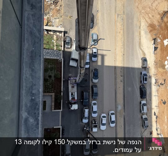 מבט מלמעלה על מנוף וכלי רכב באתר בנייה